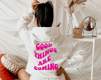 May include: White hoodie with a pink graphic that says "Good Things Are Coming" on the back.