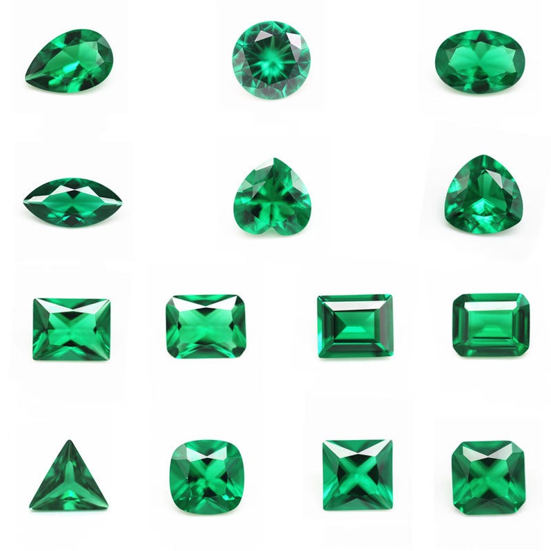 May include: Assortment of emerald green gemstones in various shapes and cuts, including round, oval, pear, heart, square, rectangle, and triangle.