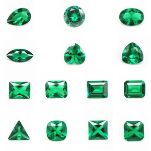 May include: Assortment of emerald green gemstones in various shapes and cuts, including round, oval, pear, heart, square, rectangle, and triangle.