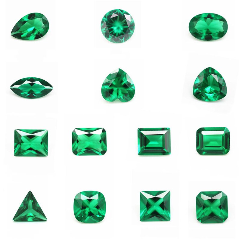 May include: Assortment of emerald green gemstones in various shapes and cuts, including round, oval, pear, heart, square, rectangle, and triangle.