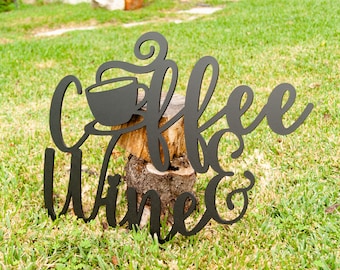 May include: Black metal sign with the words "Coffee Wine &" in a cursive font. A stylized coffee cup with steam is above the word "Coffee".