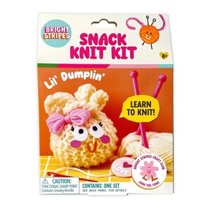 May include: A Bright Stripes Snack Knit Kit box featuring a cream-colored knitted dumpling character with a pink bow, googly eyes, and a red smile. The kit includes pink knitting needles, a ball of cream yarn, and a needle, with text reading Lil' Dumplin'.