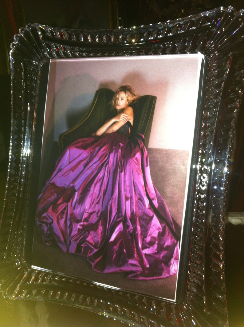 Puede incluir: Fotograf&iacute;a enmarcada de una mujer con un vestido morado vibrante. El vestido tiene una falda voluminosa. El marco es transparente con un dise&ntilde;o facetado, agregando elegancia al retrato.