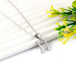 May include: A silver-toned necklace featuring a capital letter H pendant. The pendant has a polished metallic finish and is accented with a horizontal row of small, clear, sparkling stones embedded across the center bar of the letter.