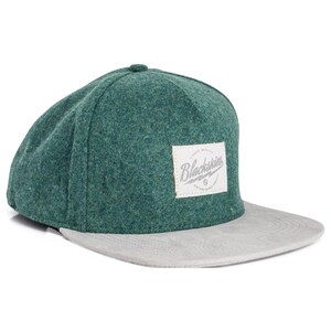 Può includere: Cappellino da baseball verde con visiera grigia. Il cappellino ha un aspetto strutturato e una toppa quadrata con la scritta "Blackskies". Classico stile a visiera piatta, per un look casual.