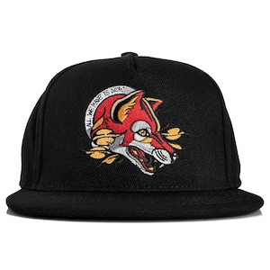 Könnte beinhalten: Schwarze Cap mit flachem Schirm und einem gestickten Design eines roten Fuchses mit gelben Akzenten. Der Text "ALL WE HAVE IS NOW" ist über dem Fuchs gestickt. Die Cap hat eine strukturierte Krone.