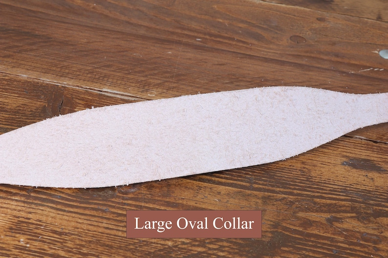 Peut inclure: Une pi&egrave;ce de cuir beige clair, textur&eacute;e et de forme ovale allong&eacute;e, pr&eacute;sentant des bords bruts et non finis. Une &eacute;tiquette rectangulaire marron avec du texte blanc est plac&eacute;e au centre en bas, affichant clairement Large Oval Collar.