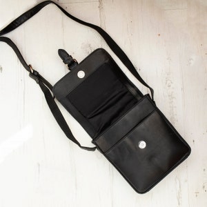 Personalised black leather bag worn crossbody by man