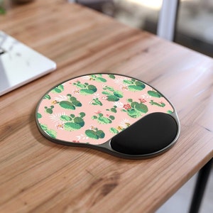 May include: A pink and green mousepad with a cactus pattern. The mousepad has a built-in wrist rest.