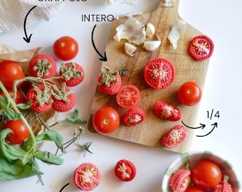 May include: A collection of crocheted tomatoes, some whole, some sliced, and some on the vine, arranged on a wooden cutting board and in a small bowl. Garlic cloves and basil leaves are also present, suggesting a culinary theme.