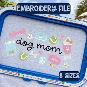 May include: An embroidery file design with the text "dog mom" surrounded by dog-themed graphics, including bones, a tennis ball, and a dog bowl. The design is displayed within a blue embroidery hoop. The text "EMBROIDERY FILE" and "8 SIZES" are also present.