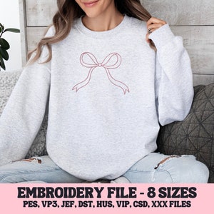 May include: A light gray sweatshirt featuring a minimalist bow design in a muted red-pink color. The text "EMBROIDERY FILE - 8 SIZES" is displayed in a pink banner at the bottom, along with file type abbreviations.
