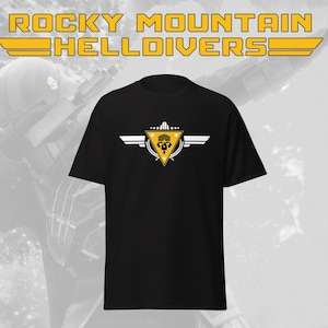 May include: Black t-shirt with a yellow, white, and black graphic. The graphic features a triangle with a skull and wings design, and the text "ROCKY MOUNTAIN HELLDIVERS" in yellow.