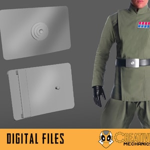 Könnte beinhalten: Zwei 3D-gedruckte Teile für ein Kostüm, eines ist ein flaches Rechteck mit einem kreisförmigen Design und das andere ist eine rechteckige Box mit einem erhöhten Balken auf einer Seite.