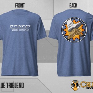 May include: A blue t-shirt with the text "L771A/V7" and "2D007 N017MT9 20400 077V7A" on the front. The back of the shirt features a circular graphic of a white boot stepping on a small spaceship with a yellow starburst.