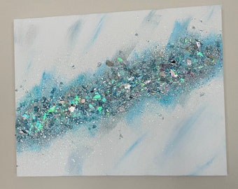 Peut inclure: Toile abstraite avec un fond blanc et une bande diagonale de paillettes iridescentes et de verre concassé dans des tons de bleu et d'argent. Des coups de pinceau bleu clair et des paillettes éparses ajoutent de la texture.