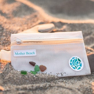 Creme mesh bag is zippered and branded with mother beach patch.  Keeps treasures safe and lets water and sand drain.