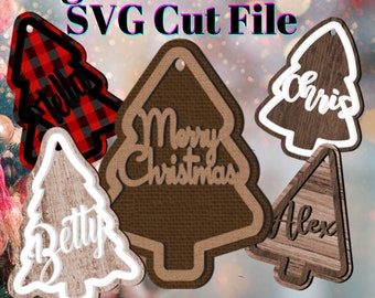 Peut inclure: Cinq fichiers de découpe SVG à télécharger numériquement pour des décorations d'arbre de Noël. Les décorations sont de styles différents, notamment un arbre en tissu écossais rouge et noir, un arbre en toile de jute brune avec le texte "Joyeux Noël" et trois arbres en bois avec les noms "Stella", "Chris" et "Betty".