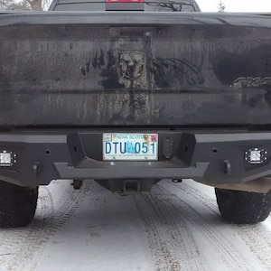 Peut inclure: Camionnette noire avec un pare-chocs arrière personnalisé doté de feux LED intégrés et d'un attelage. Le camion a une plaque d'immatriculation de la Nouvelle-Écosse qui indique "DTU 051".