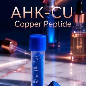 May include: A clear plastic vial with a blue cap containing vibrant blue powder, marked with 0.5, 1.0, and 1.8 ml measurements. The text AHK-CU Copper Peptide is displayed above. Glass dropper bottles with copper-coloured caps are visible in the background.