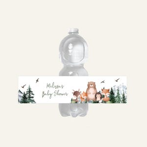 May include: A water bottle with a label featuring woodland animals and the text "Melissa's Baby Shower." The label includes illustrations of a bear, fox, deer, and hedgehog, with trees and mountains.