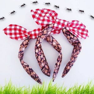 May include: Two red and white gingham fabric headbands with a woven brown and tan pattern. The headbands are tied in a bow at the top.