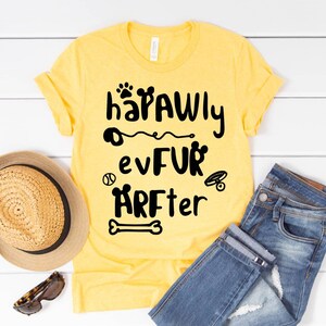 May include: Yellow t-shirt with black text that reads "hapawly evfur arfter" with a paw print, a baseball, a bone, and a dog collar graphic.
