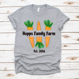 May include: Grey t-shirt with a graphic of three carrots forming the letter W. The text "Hopps Family Farm Est: 2016" is printed below the carrots.