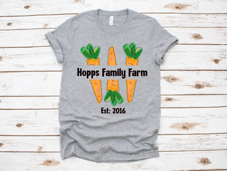May include: Grey t-shirt with a graphic of three carrots forming the letter W. The text "Hopps Family Farm Est: 2016" is printed below the carrots.