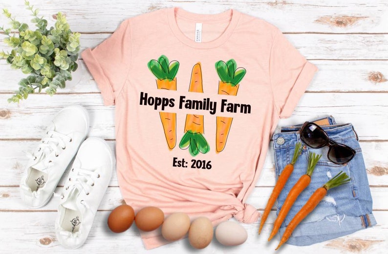 May include: A pink t-shirt with a graphic of three carrots and the text "Hopps Family Farm Est: 2016".
