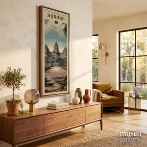 Pu&ograve; includere: Una stampa artistica da parete incorniciata verticalmente che raffigura il complesso del tempio di Angkor Wat in Cambogia, con il testo khmer "អង្គរវត្ត" in alto, esposta in una cornice di legno su una parete chiara sopra una console.