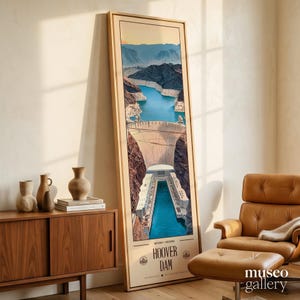May include: A tall, rectangular framed art print featuring a stylized illustration of the Hoover Dam, with blue water, rocky canyon walls, and the text 'NEVADA ARIZONA HOOVER DAM' printed at the bottom in a clean, dark sans-serif typeface.