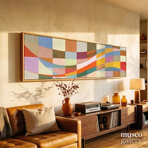 May include: A long rectangular wall art piece featuring a grid of multicolored squares in shades of blue, orange, red, yellow, and green, with wavy lines flowing across the canvas, all enclosed within a simple light-colored wooden frame.
