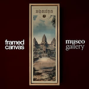 Pu&ograve; includere: Una stampa su tela incorniciata verticale con un'illustrazione del complesso del tempio di Angkor Wat. L'opera mostra le torri in pietra sotto un cielo blu con foglie di palma in alto. Il testo "framed canvas" e "museo gallery" appare sui lati.
