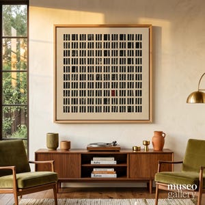 May include: A square framed wall art piece featuring a grid of black vertical bars on a light beige background, with one single small red rectangle positioned near the bottom right, displayed in a wooden frame on a light-colored wall.