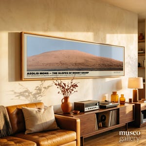Op de afbeelding: Een panoramische ingelijste wandkunstprint met een landschap van Aeolis Mons, de hellingen van Mount Sharp. De tekst luidt: AEOLIS MONS – THE SLOPES OF MOUNT SHARP. Five kilometers of layered sedimentary rock rising from the floor of Gale Crater.