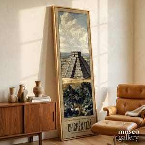May include: A tall, rectangular framed print featuring an illustration of the Chichén Itzá pyramid in Mexico. The artwork displays the stone structure amidst a lush landscape under a cloudy sky, with the text CHICHÉN ITZÁ printed at the bottom.