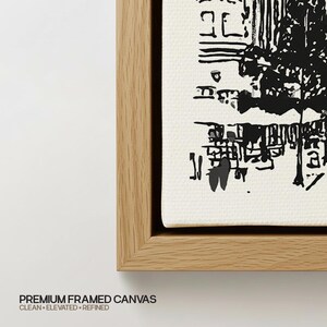 May include: A framed canvas print featuring a high-contrast black ink illustration on a textured white background. The artwork is encased in a light-toned wooden frame with a clean, straight-edged profile, showcasing a detailed graphic design.