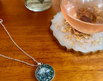 Circular pendant necklace in silver with teal backsplash