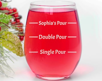 Può includere: Un bicchiere di vino in vetro trasparente riempito con un liquido rosso. Il bicchiere ha tre linee con il testo "Sophia's Pour", "Double Pour" e "Single Pour" stampato su di esso.