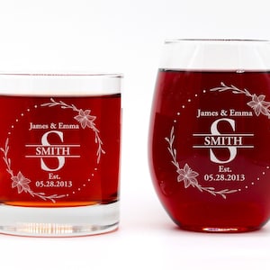 Peut inclure: Deux verres personnalisés avec un motif floral et le texte "James & Emma SMITH Est. 05.28.2013". Les verres sont remplis d'un liquide rouge.