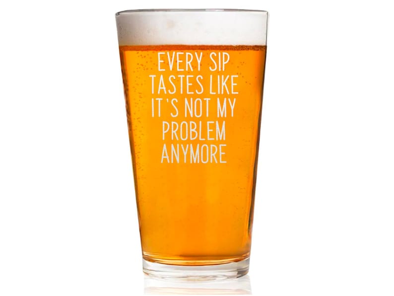 Pode incluir: Um copo de cerveja transparente cheio de cerveja &acirc;mbar e uma espuma branca. O copo tem texto branco que diz: "EVERY SIP TASTES LIKE IT'S NOT MY PROBLEM ANYMORE".