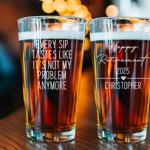 Pode incluir: Dois copos de cerveja cheios de cerveja, cada um com texto branco. Um copo diz: "Cada gole tem gosto de n&atilde;o ser mais meu problema". O outro copo diz: "Feliz aposentadoria 2025 Christopher".