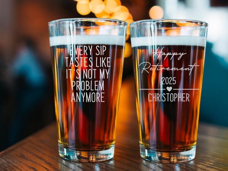Pode incluir: Dois copos de cerveja cheios de cerveja, cada um com texto branco. Um copo diz: "Cada gole tem gosto de n&atilde;o ser mais meu problema". O outro copo diz: "Feliz aposentadoria 2025 Christopher".