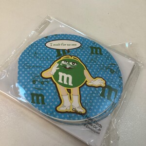 May include: A set of note cards featuring a green M&M's character on a blue background with white polka dots. The character is saluting and the text "I melt for no one" is displayed. The set includes 8 note cards and 8 envelopes.