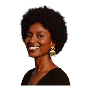 May include: A smiling person with dark skin and an afro hairstyle. They are wearing gold-colored earrings in the shape of a comb. The background is white.