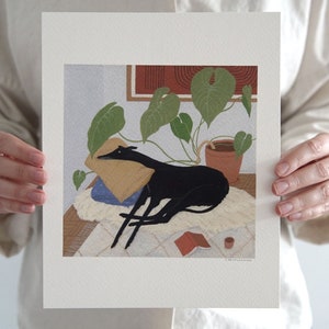 May include: A black and white illustration of a dog sleeping on a rug with a plant in a terracotta pot in the background. The dog is lying on a pillow and there is a book and a cup on the rug.