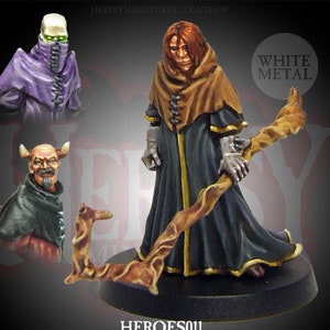 May include: A painted miniature figure of a wizard with a staff, wearing a brown robe with gold trim. The figure is standing on a black base. The miniature is labelled "HEROES011 SEBASTIAN: Apprentice/Warlock/Liche" and "WHITE METAL".