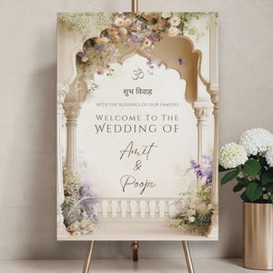 May include: A wedding welcome sign featuring floral decorations and the names Amit & Pooja. The sign is on a gold easel, with a gold vase of white flowers. Text is in English and Hindi.
