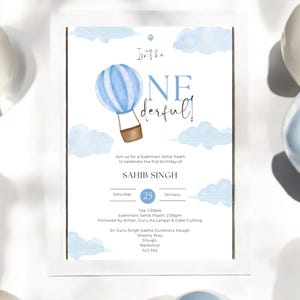 May include: A blue and white hot air balloon with a basket is floating in a sky with white clouds. The text "Inthe ONE derful!" is written in black. The invitation is for a Sukhmani Sahib Paath to celebrate the first birthday of Sahib Singh. The event is on Saturday, January 25th at 1:30pm. The address is Sri Guru Singh Sabha Gurdwara Slough, Sheety Way, Slough, Berkshire, 542 555.